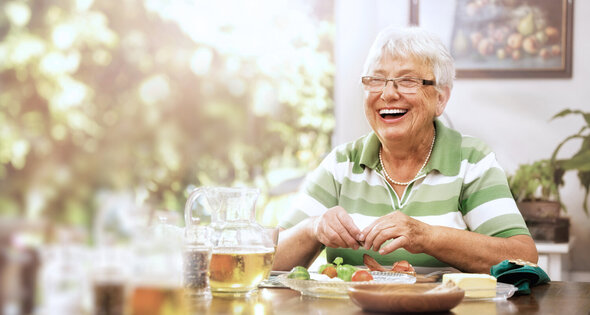 Smiling senior woman eating snack